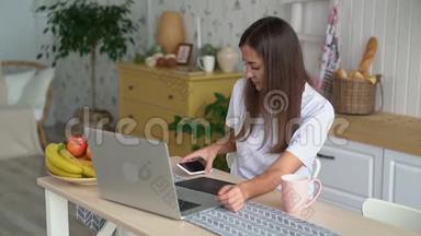 年轻的女人在笔记本电脑上工作，带着平板电脑，接电话和电话，慢动作